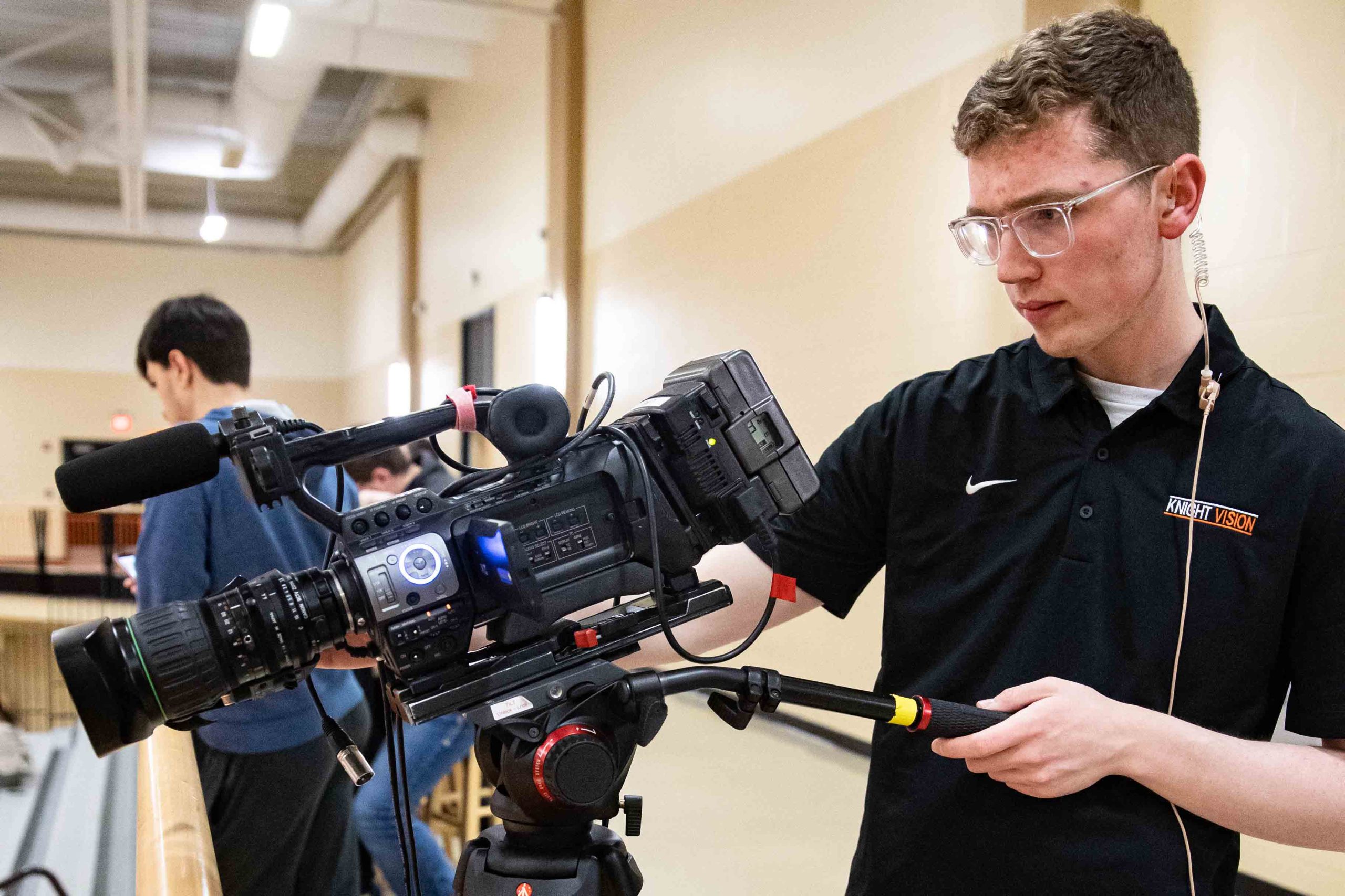 Zach Hiney runs the Knight Vision camera during a basketball game.