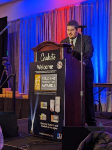 Joshua Hamlyn accepts the Crystal Pillar on behalf of the Knight Vision production team.