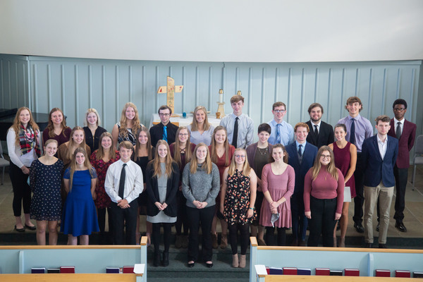 New members of the Phi Eta Sigma honor society stand at the front of the Wartburg Chapel.