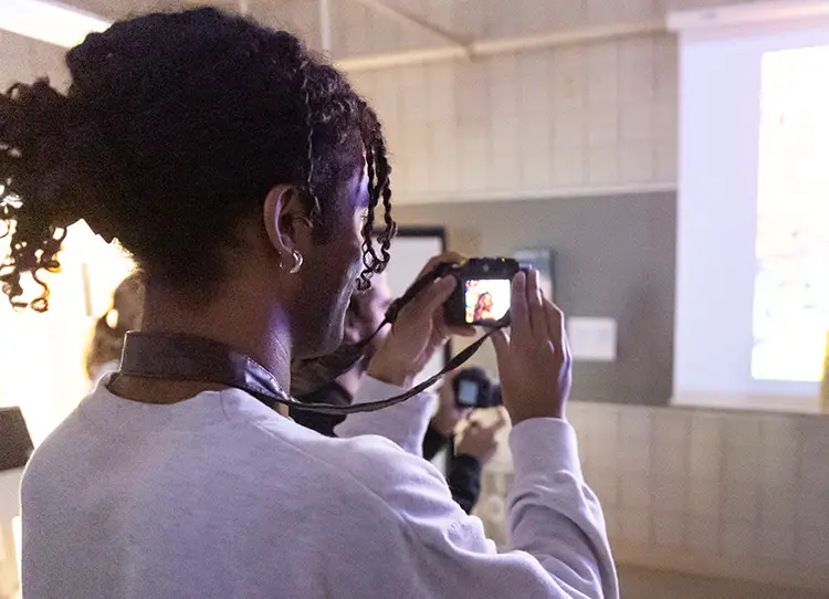Student learning about photography and testing a camera in class