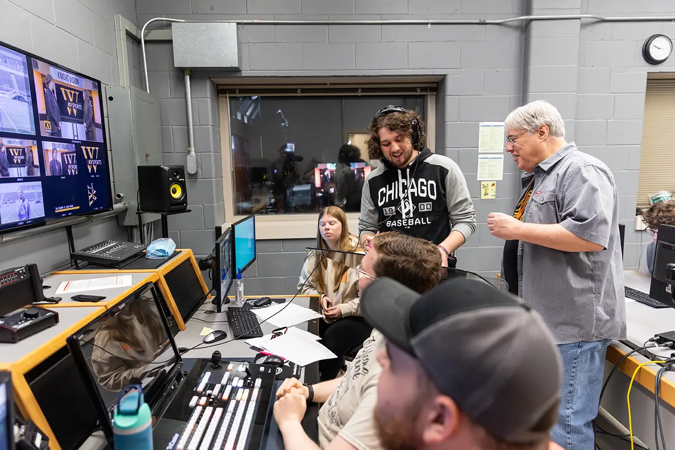 Students with professor in the TV control room