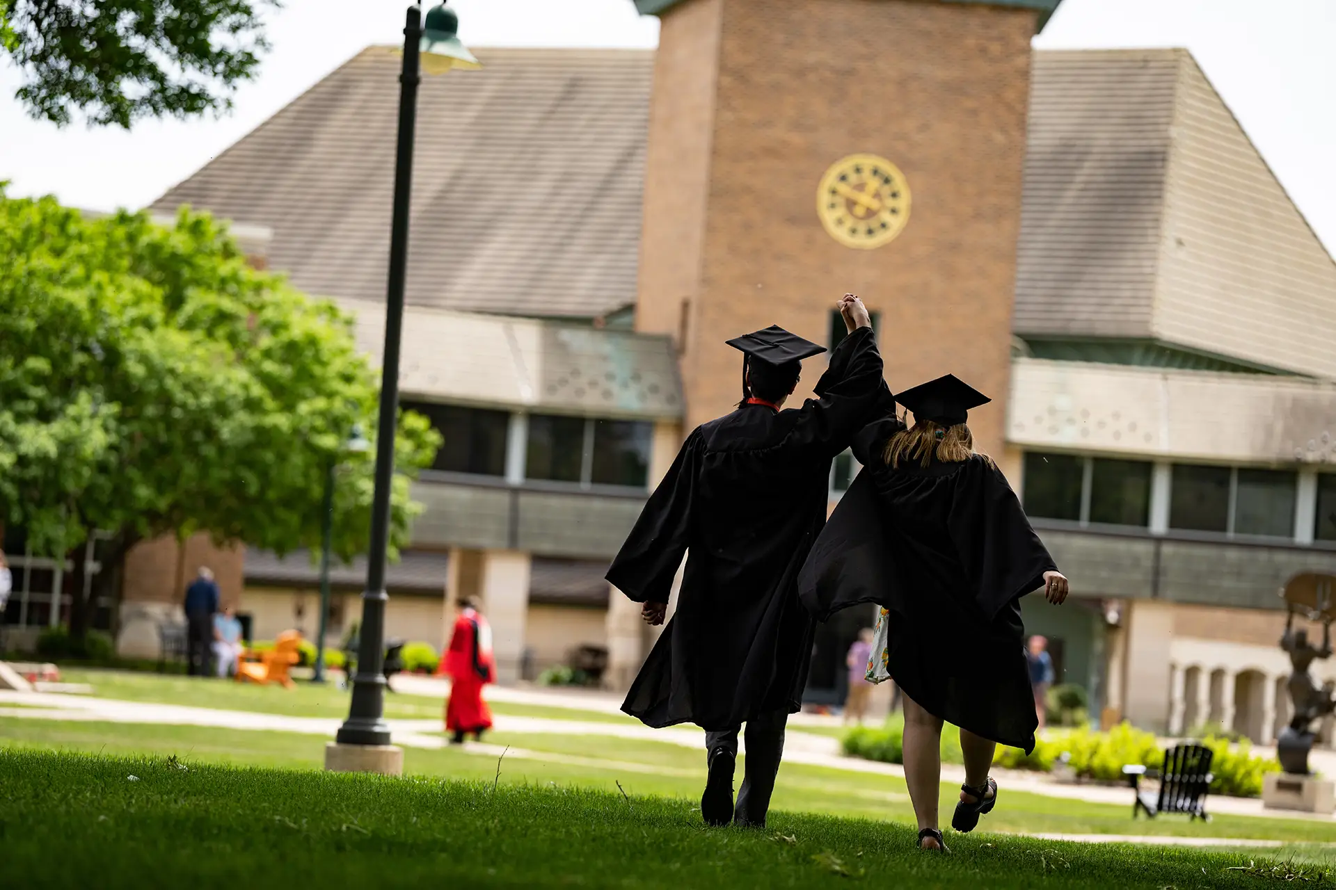 Students walking toward the chapel in their graduation gowns