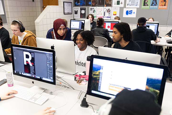 Computer graphic design class - professor helping a student