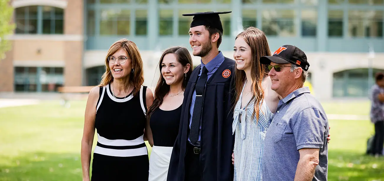 Family taking photo with graduate at commencement