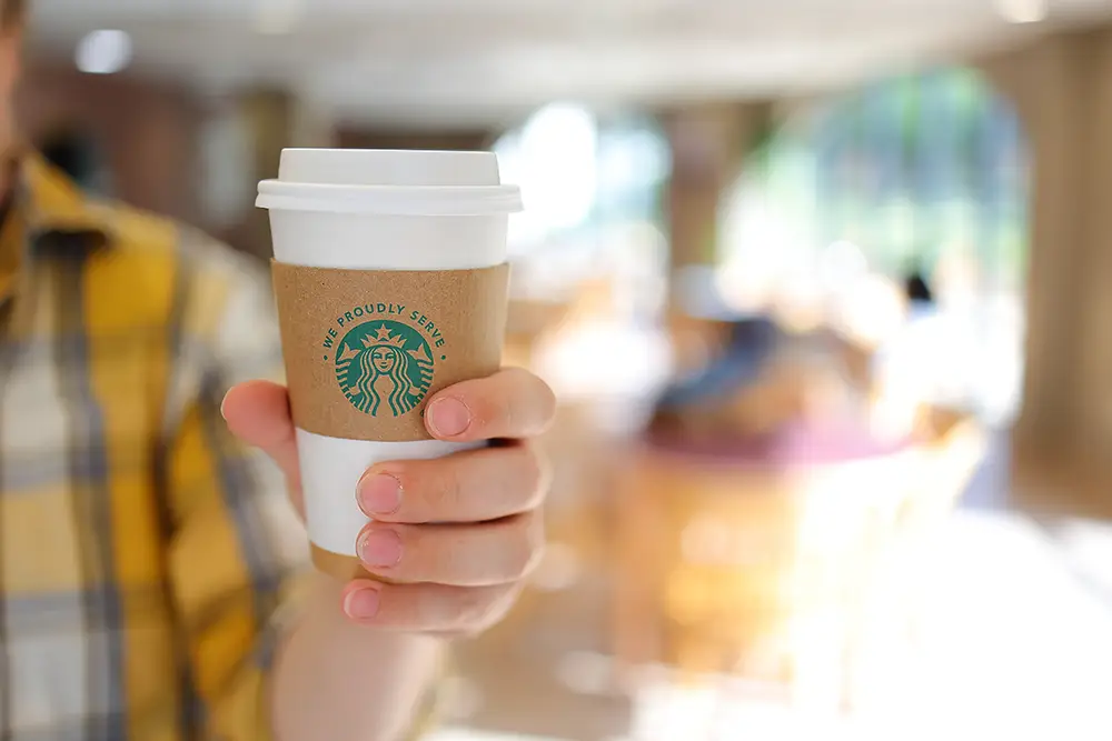 Holding up a Starbucks coffee cup