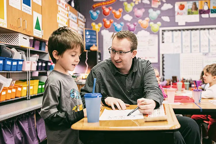 Student teaching with Wartburg student in the classroom working with an elementary student