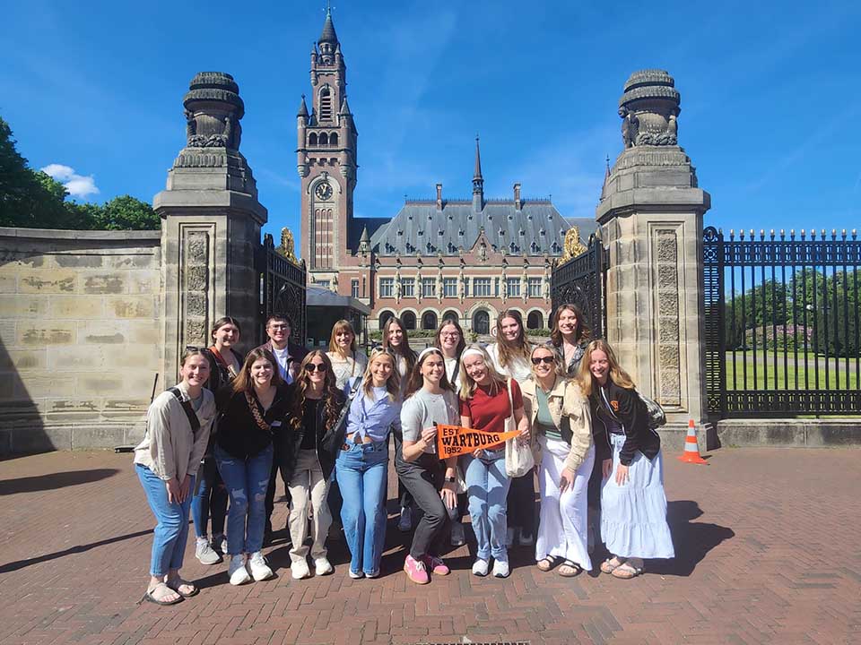 Students stand in front of a large home or castle in the netherlands