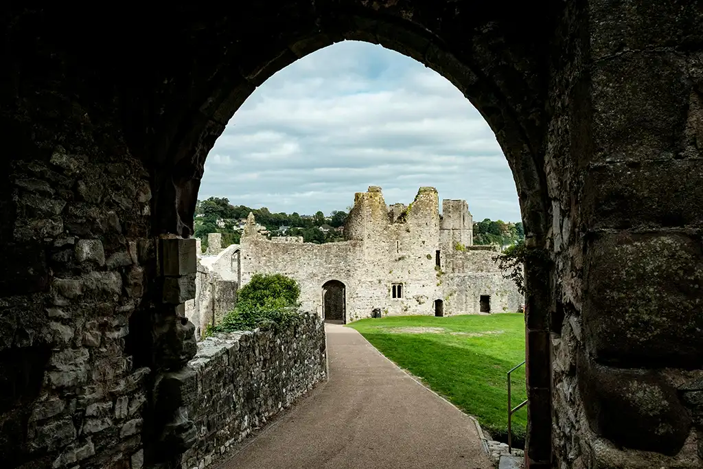 A castle in Wales is seen through the negative space of a bridge
