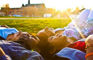 Students laying on the grass with a lens flare