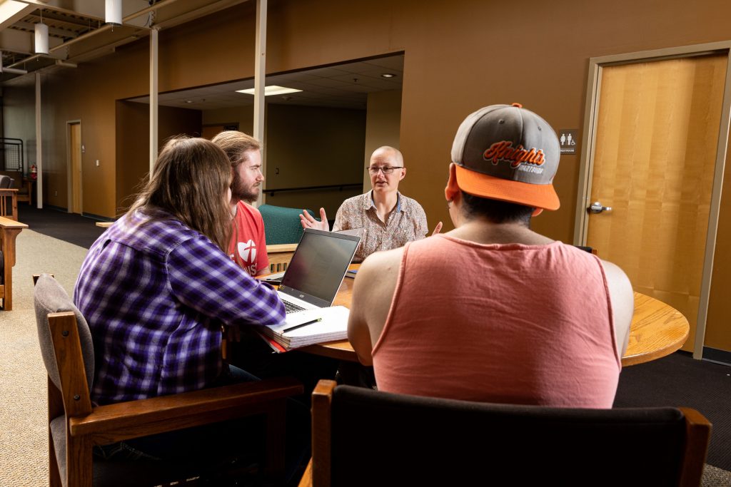 Students and faculty having a conversation in Cardinal Commons