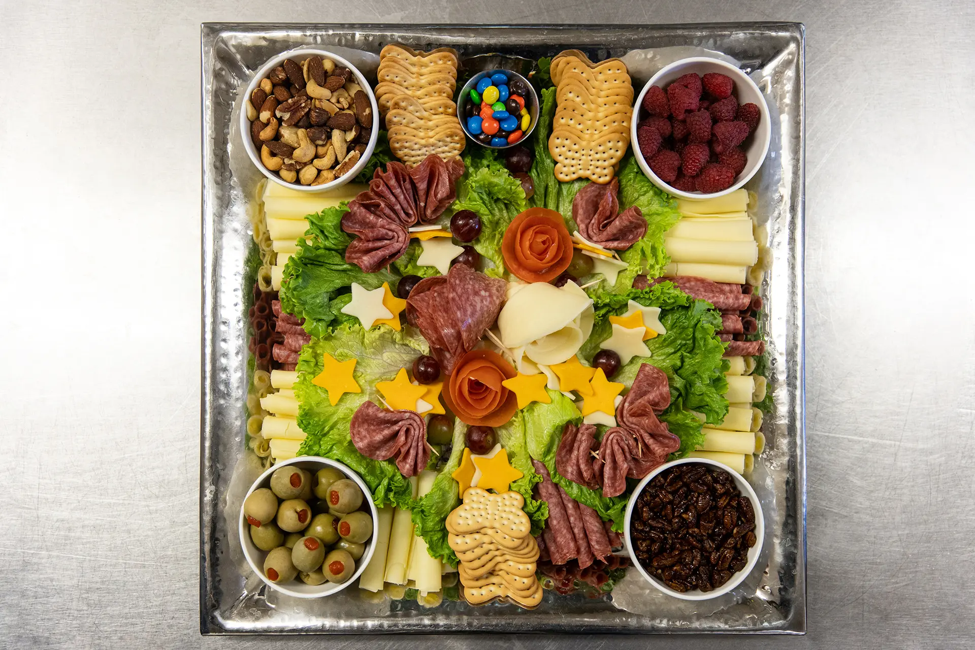 A charcuterie board from Wartburg Catering, featuring a variety of meats, cheeses, crackers, and other snacks.