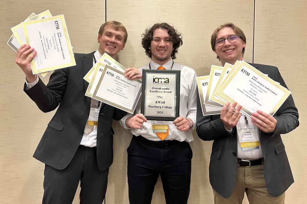 From left to right, Landon Jepson, Chris Guerrero and Caleb Kammerer stand with the awards won by Wartburg student media. 