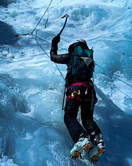 Natalie Bonthius uses an ice pick to scale an icy mountain. 