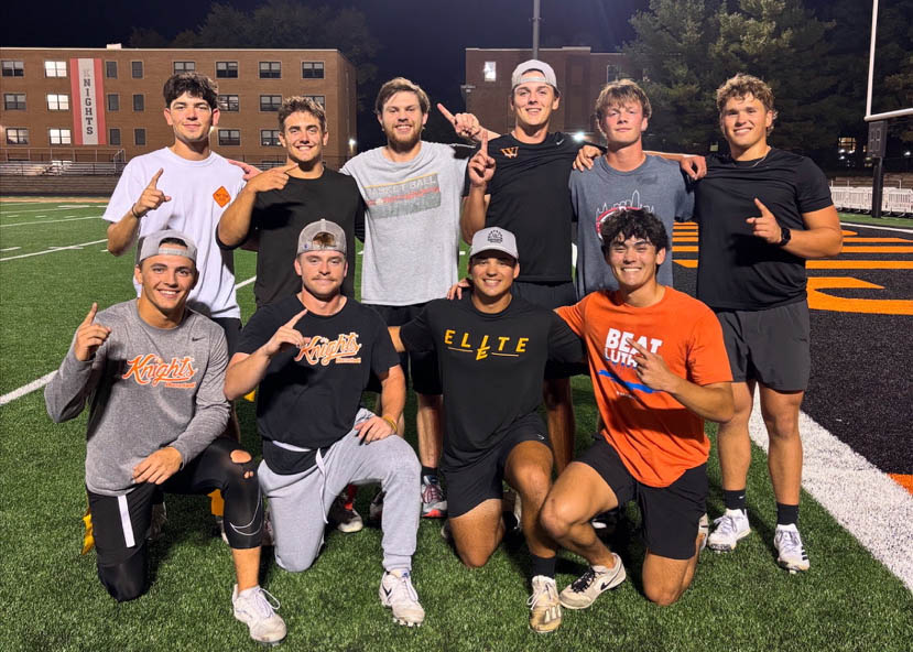 Aiden Tobin and a group of guys pose on the football field