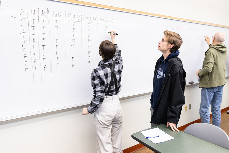 Students at a whiteboard working on math problems
