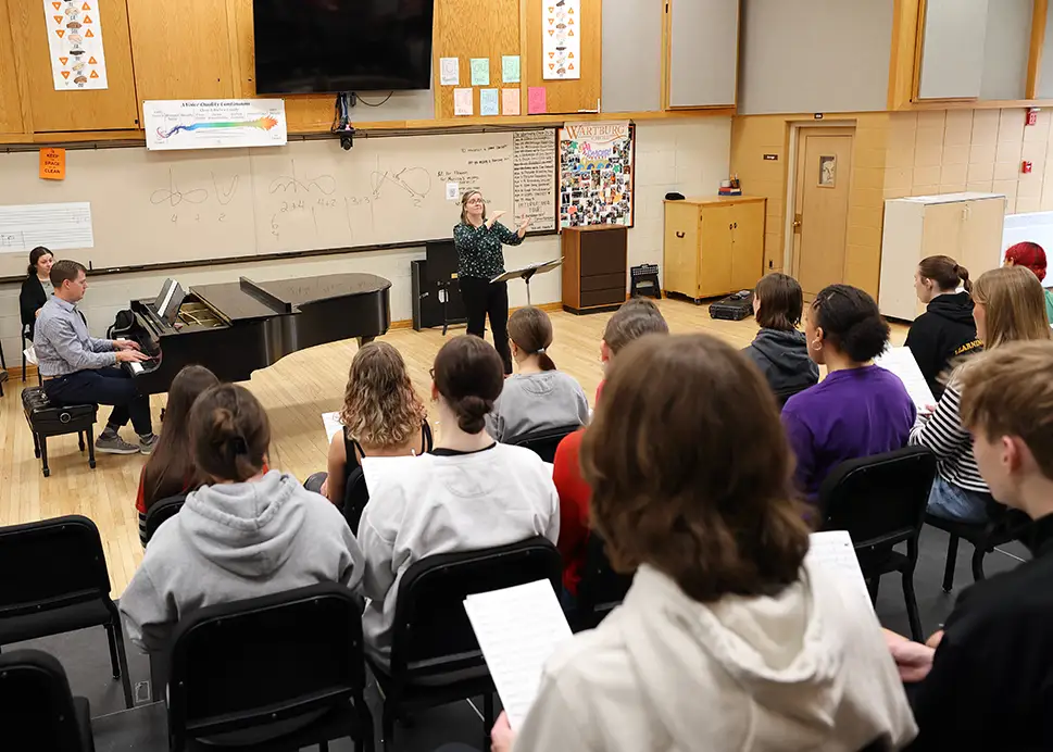 Greta Nelson, Waverly-Shell Rock High School vocal music director, conducts the W-SR Chamber Choir on "Good Night, Dear Heart," written by Dan Forrest, who is accompanying them on the piano. 