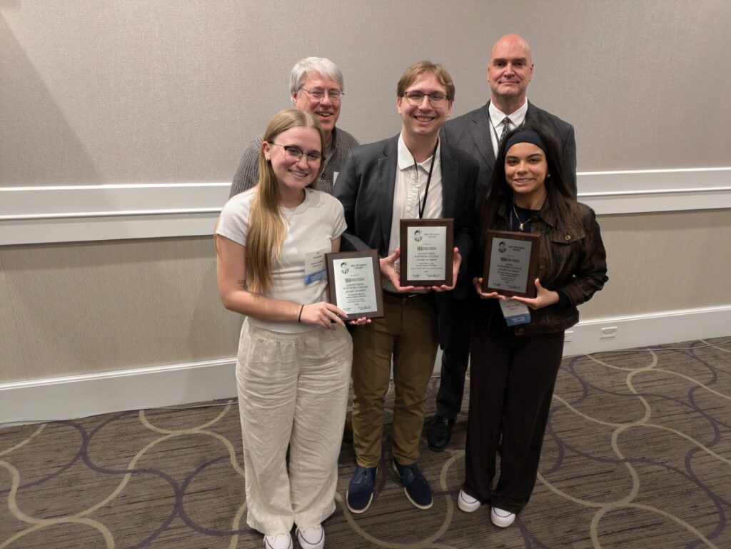 (front left to right) Ali Parkhurst, Caleb Kammerer, Karma Goodson each holding an award plaque. Back row left to right Ron Johnson and Will Buss