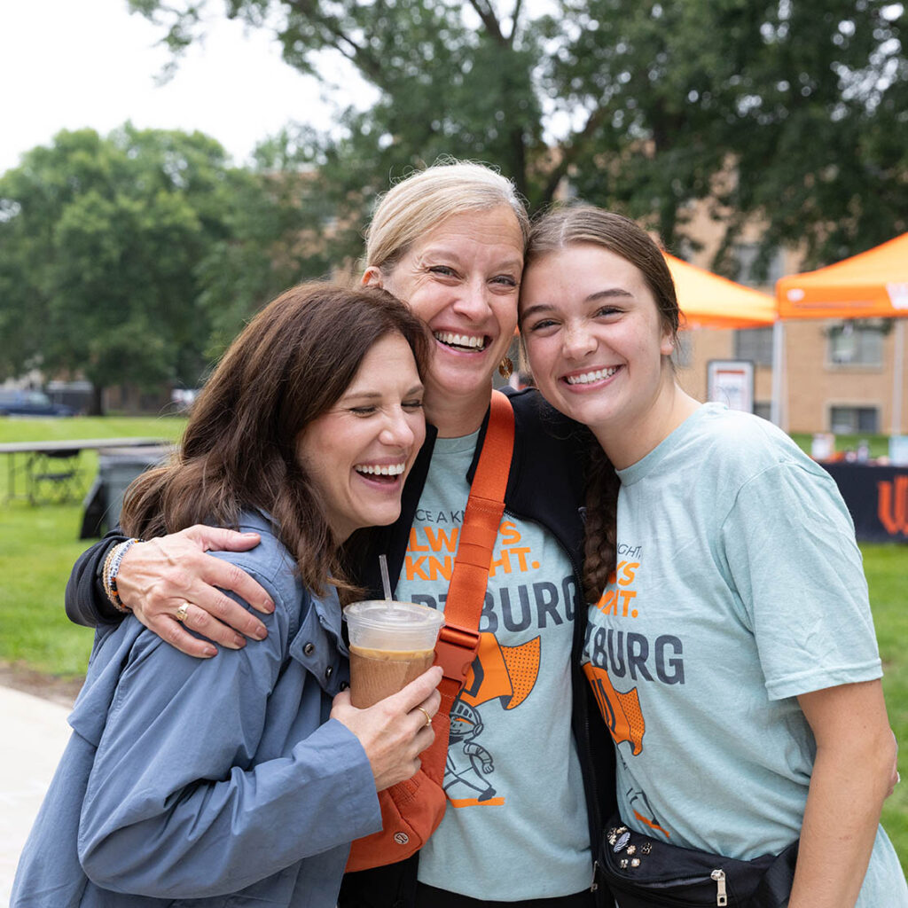 Lindsey Leonard, President Rebecca Ehretsmas and Erica Knupp embrace at move-in