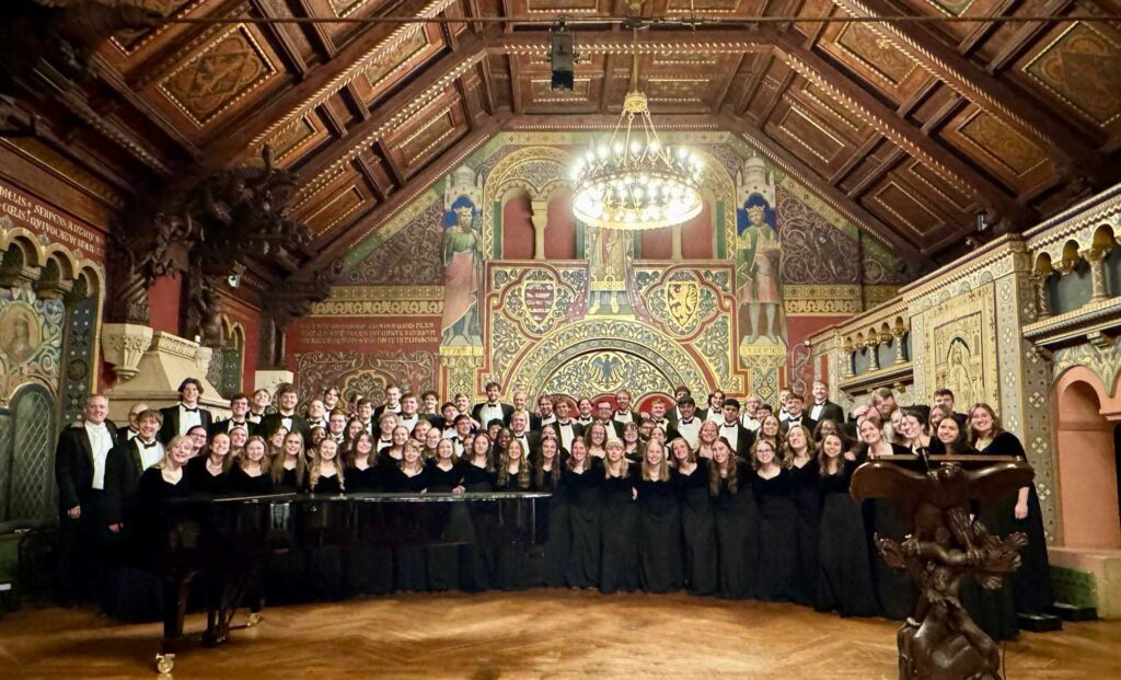 Wartburg Choir members stand at the front of the concert space inside the Wartburg Castle in Eisenach Germany.