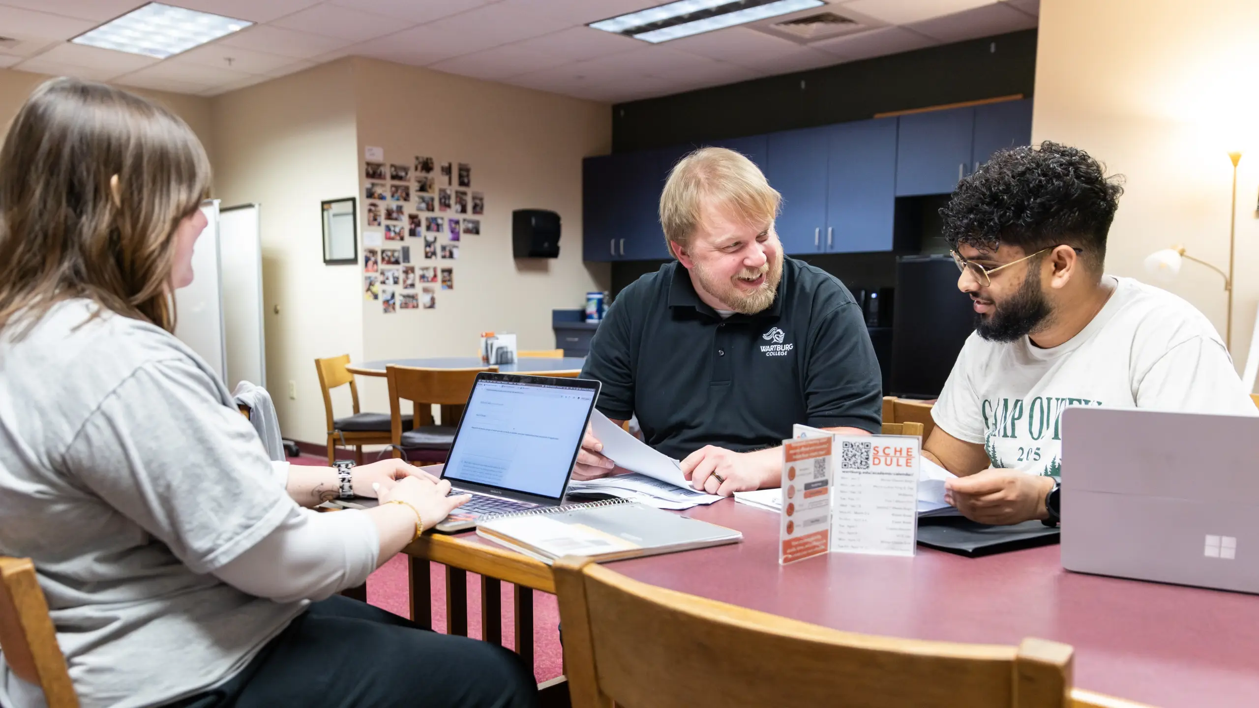 Kyle Haiman works with two students at a table in the Academic Resource Center