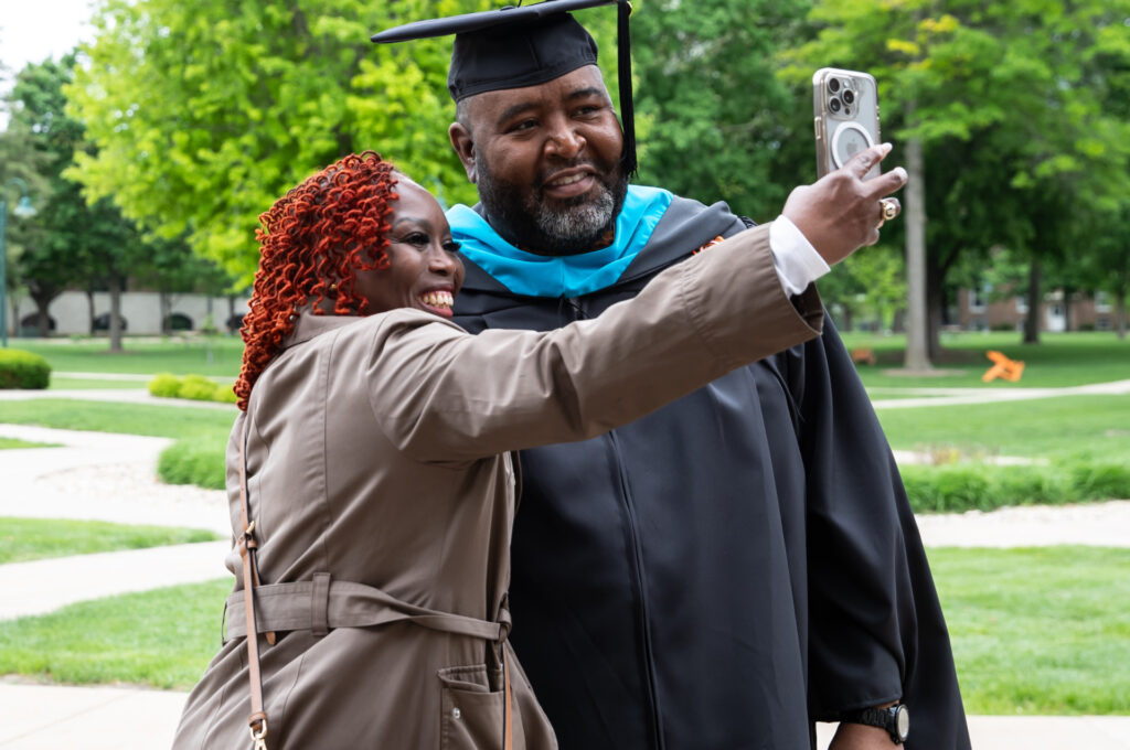Graduate student at Commencement taking a selfie