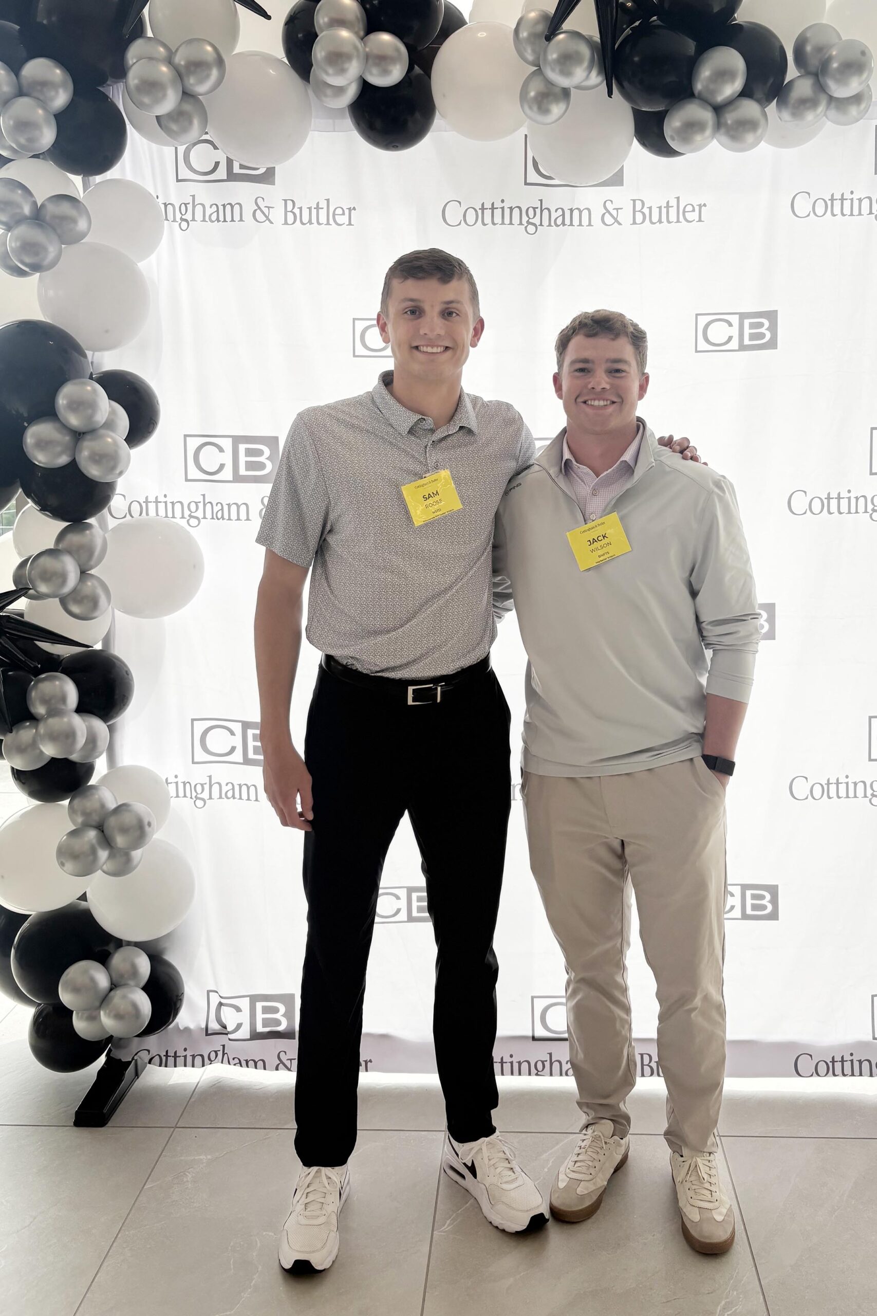 Sam Roose and Jack Willson stand in front of a Cottingham and Butler backdrop