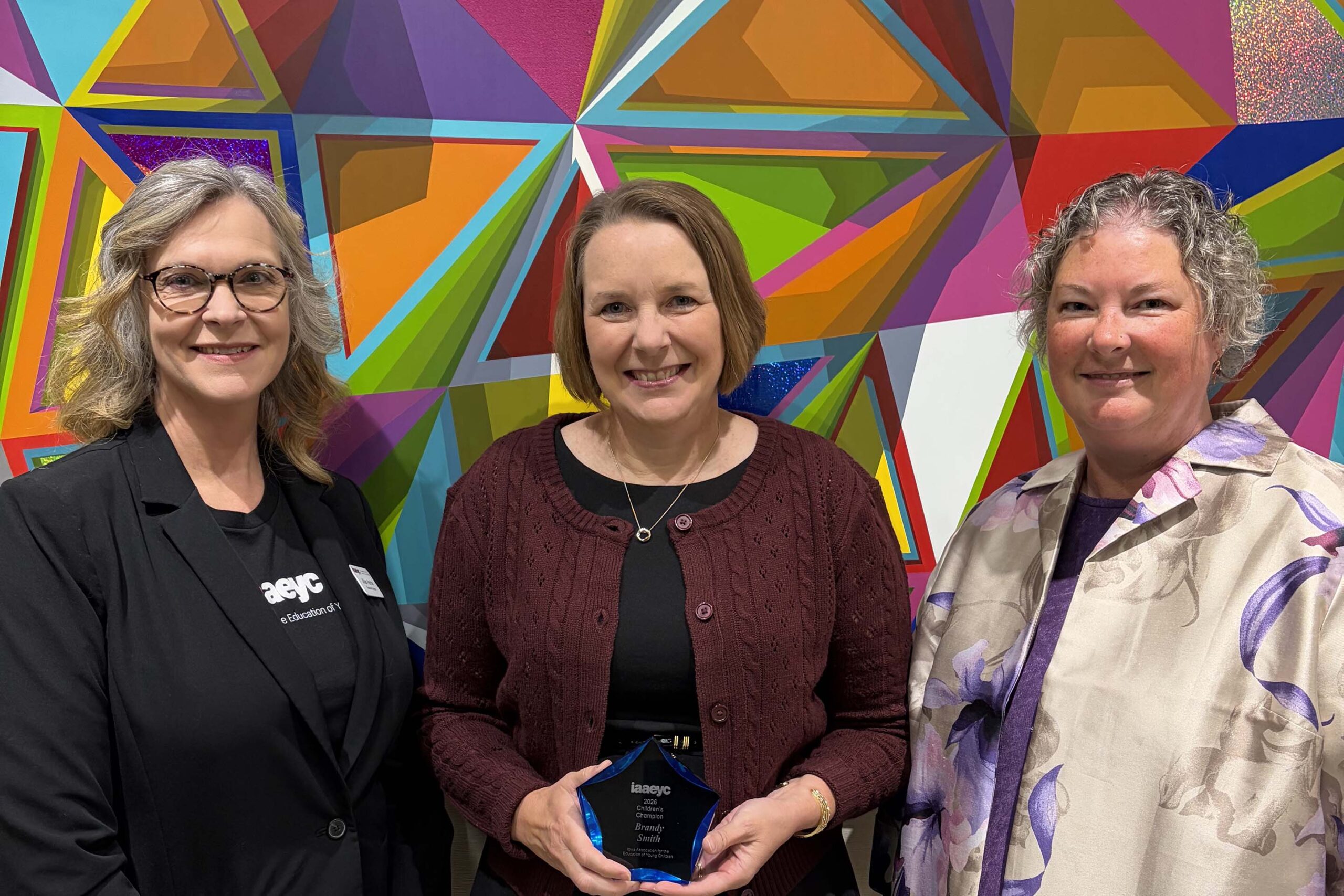 Brandy Smith stands between two unidentified woman. She is holding her award.